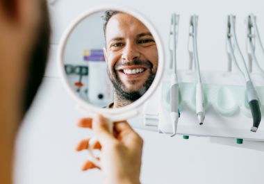 Dental patient admiring his smile in a mirror