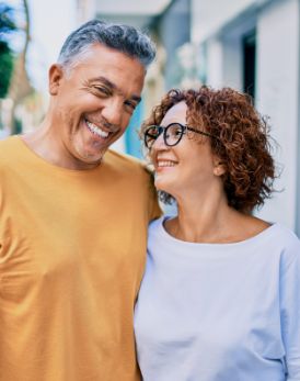 Man and woman smiling at each other on a city sidewalk