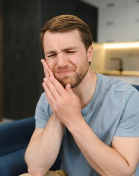 Man holding the side of his face in pain