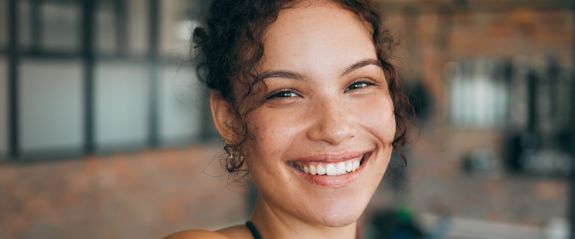 Woman with curly dark hair grinning